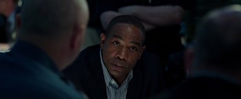 Movie still from “Patriots Day” (2016), directed by Peter Berg – A person wearing a suit and tie; Close Up shot, Over the shoulder angle