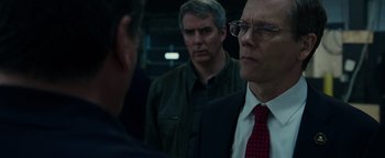 Movie still from “Patriots Day” (2016), directed by Peter Berg – A man in a suit and tie standing next to another man in a suit and tie; Close Up shot, Over the shoulder angle