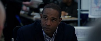 Movie still from “Patriots Day” (2016), directed by Peter Berg – A person wearing a suit and tie; Close Up shot, Over the shoulder angle