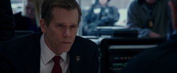 Movie still from “Patriots Day” (2016), directed by Peter Berg – A person wearing a suit and tie; Close Up shot, Over the shoulder angle