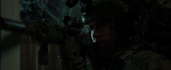 Movie still from “Patriots Day” (2016), directed by Peter Berg – A man wearing a helmet and holding a rifle; Close Up shot, Over the shoulder angle