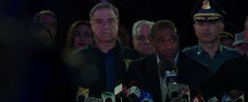 Movie still from “Patriots Day” (2016), directed by Peter Berg – A group of men standing next to each other in front of microphones; Close Up shot, Over the shoulder angle