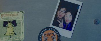 Movie still from “Patriots Day” (2016), directed by Peter Berg – A picture of two people and a patch on a table; Extreme Close Up shot, Overhead angle