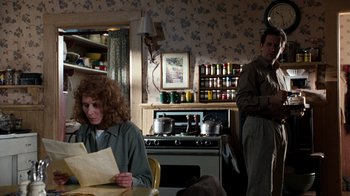 Movie still from “The Bridges of Madison County” (1995), directed by Clint Eastwood – A woman sitting at a table in front of an oven; Medium shot, Over the shoulder angle