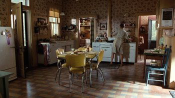 Movie still from “The Bridges of Madison County” (1995), directed by Clint Eastwood – An old fashioned kitchen with a woman preparing a meal; Wide shot, High angle