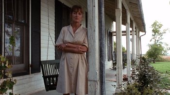 Movie still from “The Bridges of Madison County” (1995), directed by Clint Eastwood – A woman standing on the porch of an old house; Wide shot, Low angle