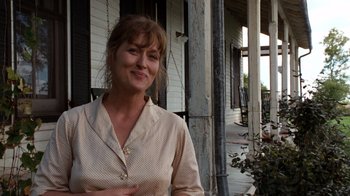 Movie still from “The Bridges of Madison County” (1995), directed by Clint Eastwood – A woman standing in front of a building; Medium shot, Over the shoulder angle