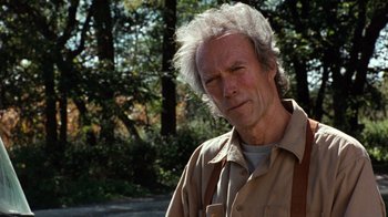 Movie still from “The Bridges of Madison County” (1995), directed by Clint Eastwood – A person wearing a shirt with trees in the background; Close Up shot, Over the shoulder angle