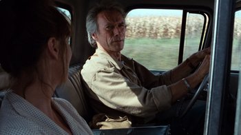 Movie still from “The Bridges of Madison County” (1995), directed by Clint Eastwood – An older man and woman driving in the back of a car; Medium shot, Over the shoulder angle