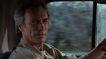 Movie still from “The Bridges of Madison County” (1995), directed by Clint Eastwood – A man sitting in the driver's seat of a car; Close Up shot, Over the shoulder angle