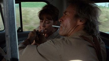Movie still from “The Bridges of Madison County” (1995), directed by Clint Eastwood – A man and a woman are sitting in a car; Medium shot, Over the shoulder angle