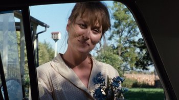 Movie still from “The Bridges of Madison County” (1995), directed by Clint Eastwood – A woman holding a bunch of flowers in her hand; Close Up shot, Over the shoulder angle
