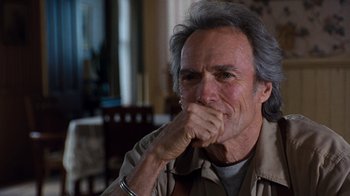 Movie still from “The Bridges of Madison County” (1995), directed by Clint Eastwood – An older man with grey hair is sitting at a table; Close Up shot, Over the shoulder angle