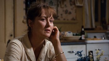 Movie still from “The Bridges of Madison County” (1995), directed by Clint Eastwood – A person sitting at a table holding a cell phone; Close Up shot, Over the shoulder angle
