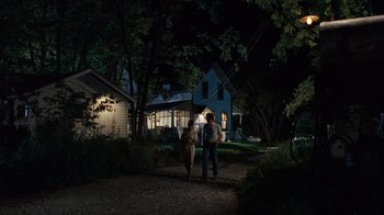 Movie still from “The Bridges of Madison County” (1995), directed by Clint Eastwood – Two people are walking in the dark near a house; Wide shot, Over the shoulder angle