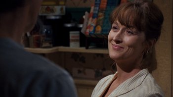 Movie still from “The Bridges of Madison County” (1995), directed by Clint Eastwood – A person sitting in front of a table; Close Up shot, Over the shoulder angle