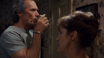 Movie still from “The Bridges of Madison County” (1995), directed by Clint Eastwood – A man and a woman looking in the same direction in the same mirror; Close Up shot, Over the shoulder angle