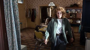 Movie still from “The Bridges of Madison County” (1995), directed by Clint Eastwood – A woman standing in a room with a lamp on the wall; Medium shot, Over the shoulder angle