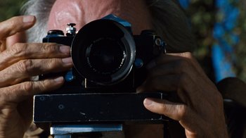 Movie still from “The Bridges of Madison County” (1995), directed by Clint Eastwood – A person holding a camera in their hands; Extreme Close Up shot, Low angle