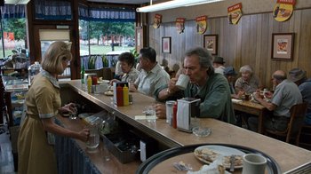 Movie still from “The Bridges of Madison County” (1995), directed by Clint Eastwood – A group of people sitting at a table eating; Wide shot, Over the shoulder angle