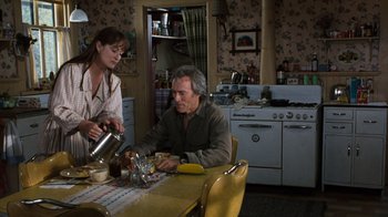 Movie still from “The Bridges of Madison County” (1995), directed by Clint Eastwood – A man sitting at a dining table with a woman; Medium shot, High angle