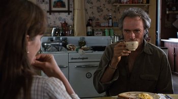 Movie still from “The Bridges of Madison County” (1995), directed by Clint Eastwood – A man and a woman sitting at a table drinking coffee; Medium shot, Over the shoulder angle