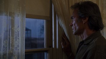 Movie still from “The Bridges of Madison County” (1995), directed by Clint Eastwood – A man looking out of a window at night; Medium shot, Low angle