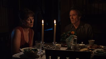 Movie still from “The Bridges of Madison County” (1995), directed by Clint Eastwood – A man and a woman sitting at a dinner table; Medium shot, Over the shoulder angle
