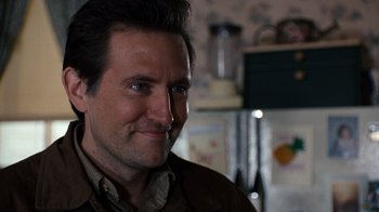 Movie still from “The Bridges of Madison County” (1995), directed by Clint Eastwood – A person smiling at the camera; Close Up shot, Over the shoulder angle