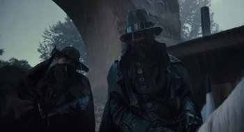 Movie still from “The Brothers Grimm” (2005), directed by Terry Gilliam – A man in a black coat and a black hat; Medium shot, Low angle