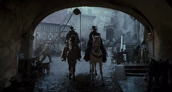 Movie still from “The Brothers Grimm” (2005), directed by Terry Gilliam – Two men on horses are walking through a tunnel; Wide shot, Low angle