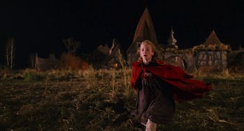 Movie still from “The Brothers Grimm” (2005), directed by Terry Gilliam – A little girl in a red cape walking in a field at night; Medium shot, Low angle