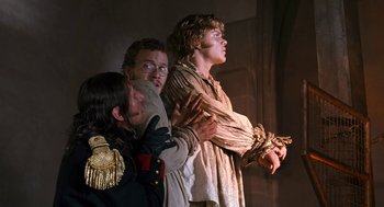 Movie still from “The Brothers Grimm” (2005), directed by Terry Gilliam – Three men in military garb are holding hands; Medium shot, Low angle