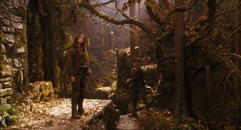 Movie still from “The Brothers Grimm” (2005), directed by Terry Gilliam – Two people in the woods near some trees; Wide shot, Low angle