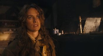 Movie still from “The Brothers Grimm” (2005), directed by Terry Gilliam – A woman with long brown hair standing in a dark room; Close Up shot, Over the shoulder angle