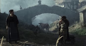 Movie still from “The Brothers Grimm” (2005), directed by Terry Gilliam – A man walking across a bridge near a horse; Wide shot, Low angle