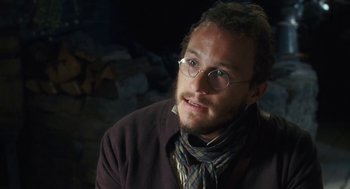 Movie still from “The Brothers Grimm” (2005), directed by Terry Gilliam – A person wearing glasses and a jacket; Close Up shot, Over the shoulder angle