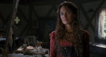 Movie still from “The Brothers Grimm” (2005), directed by Terry Gilliam – A woman with long brown curly hair wearing a red and black dress; Close Up shot, Over the shoulder angle