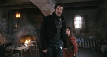 Movie still from “The Brothers Grimm” (2005), directed by Terry Gilliam – A man standing next to a woman in front of a fireplace; Medium shot, Low angle