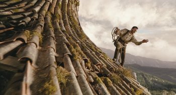 Movie still from “The Brothers Grimm” (2005), directed by Terry Gilliam – A man on a bicycle is climbing up a mountain; Wide shot, Low angle