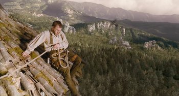 Movie still from “The Brothers Grimm” (2005), directed by Terry Gilliam – A man sitting on top of a wooden structure; Wide shot, Low angle