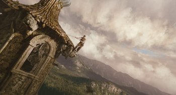 Movie still from “The Brothers Grimm” (2005), directed by Terry Gilliam – A man flying through the air on top of a building; Extreme Wide shot, Low angle