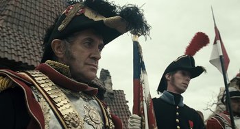 Movie still from “The Brothers Grimm” (2005), directed by Terry Gilliam – A man in a military uniform holding a flag; Medium shot, Low angle