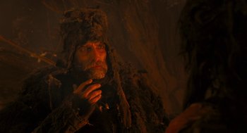 Movie still from “The Brothers Grimm” (2005), directed by Terry Gilliam – A man wearing a camouflage suit and a hat; Close Up shot, Over the shoulder angle