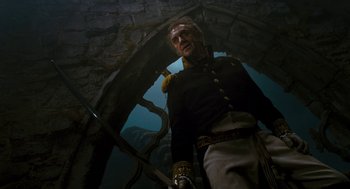 Movie still from “The Brothers Grimm” (2005), directed by Terry Gilliam – An old man in a military uniform standing next to a wall; Medium shot, Low angle