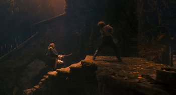 Movie still from “The Brothers Grimm” (2005), directed by Terry Gilliam – Two people are fighting on a rock ledge; Wide shot, Low angle