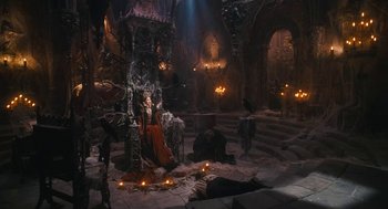 Movie still from “The Brothers Grimm” (2005), directed by Terry Gilliam – A woman sitting on a throne in a room filled with lights; Wide shot, High angle