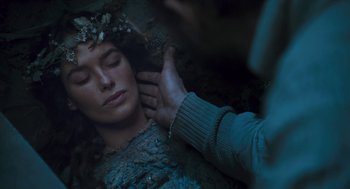 Movie still from “The Brothers Grimm” (2005), directed by Terry Gilliam – A woman is laying in the grass wearing a crown; Close Up shot, Overhead angle