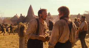 Movie still from “The Brothers Grimm” (2005), directed by Terry Gilliam – Two men talking to each other while standing in a field; Medium shot, Over the shoulder angle