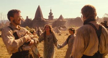 Movie still from “The Brothers Grimm” (2005), directed by Terry Gilliam – A group of people standing in the middle of a field holding hands; Wide shot, Low angle